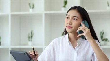 Güzel Asyalı kadın yöneticiler, işletme yöneticileri, pazarlama yöneticileri pazarlama için şirketle iletişime geçmek üzere müşterilerle telefonda konuşuyorlar. Pazarlama yönetimi kavramı.