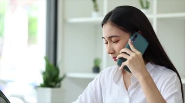 Güzel Asyalı kadın yöneticiler, işletme yöneticileri, pazarlama yöneticileri pazarlama için şirketle iletişime geçmek üzere müşterilerle telefonda konuşuyorlar. Pazarlama yönetimi kavramı.