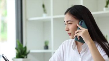 Güzel Asyalı kadın yöneticiler, işletme yöneticileri, pazarlama yöneticileri pazarlama için şirketle iletişime geçmek üzere müşterilerle telefonda konuşuyorlar. Pazarlama yönetimi kavramı.