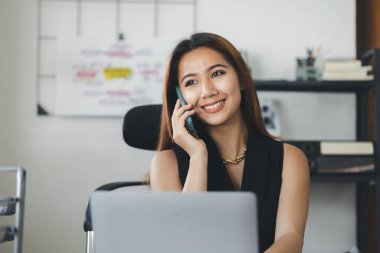Telefonda konuşan Asyalı bir kadın, bir girişim şirketinde satış elemanı, ürün ve promosyon satmak için müşterileri arıyor. Telefon kanalları aracılığıyla ürün satma kavramı.