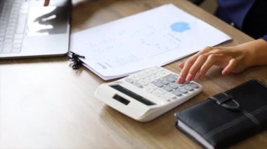 A female financier is reviewing company financial documents, monthly financial statement summary from the finance department. The concept of managing the company's finances for accuracy and growth.