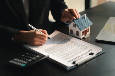 The salesperson of the housing estate in the project is preparing and verifying the contract of sale for the customer who will enter the contract. Concept of selling housing estates and real estate.
