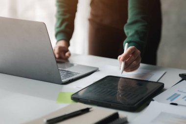 Business men are looking at the company's financial documents on tablets to analyze problems and find solutions before bringing the information to a meeting with a partner. Financial concept.