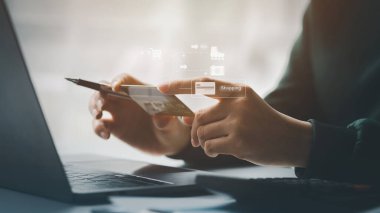Kredi kartı tutan bir kadın, internet üzerinden mal ve hizmetleri ödemek için kredi kartı kullanıyor, online alışveriş için kredi kartı kullanma, internet sitesinden mal ve hizmet sipariş etme kavramı.