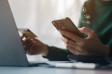 Kredi kartı tutan bir kadın, internet üzerinden mal ve hizmetleri ödemek için kredi kartı kullanıyor, online alışveriş için kredi kartı kullanma, internet sitesinden mal ve hizmet sipariş etme kavramı.