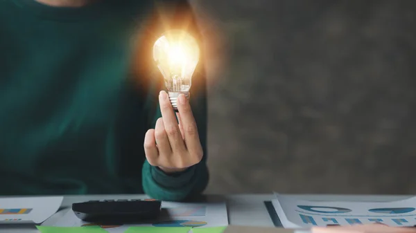 Woman holding glowing lamp, Creative new idea. Innovation, brainstorming, strategizing to make the business grow and be profitable. Concept execution, strategy planning and profit management.