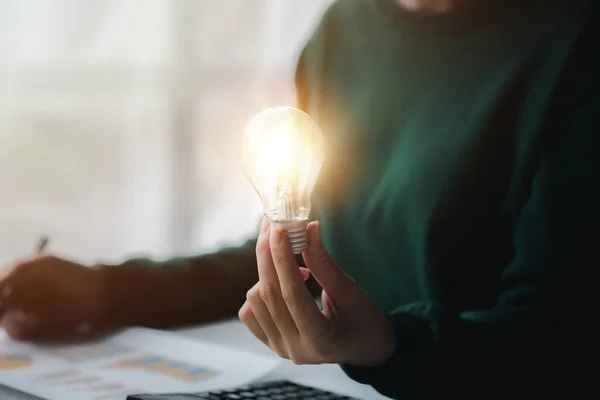 Woman holding glowing lamp, Creative new idea. Innovation, brainstorming, strategizing to make the business grow and be profitable. Concept execution, strategy planning and profit management.