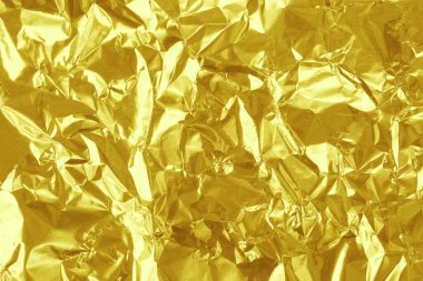 Parlak altın folyo desenli arka plan, buruşuk ve dalgalı sarı ambalaj kağıdı deseni.