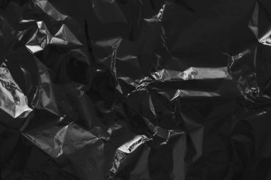 Parlak siyah folyo dokusu, buruşuk ve dalgalı ambalaj kağıdı deseni.