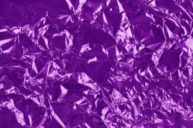 Shiny purple foil texture background, pattern of violet wrapping paper with crumpled and wavy.