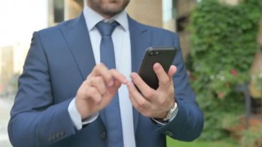 Sokakta yürürken Smartphone kullanan İşadamının ellerini kapat