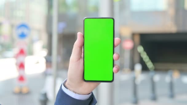 持用绿色彩色屏幕的智能手机的商人 — 图库视频影像