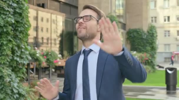 Бізнесмен танцює з радістю, коли ходить по вулиці — стокове відео