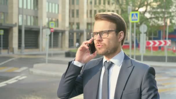 Homme d'affaires parlant au téléphone tout en marchant dans la rue — Video