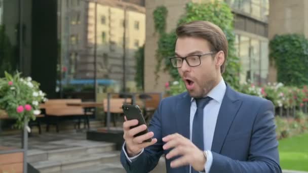Homme d'affaires Célébration sur Smartphone tout en marchant dans la rue au ralenti — Video
