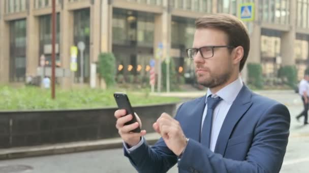 Homme d'affaires utilisant Smartphone tout en marchant dans la rue — Video
