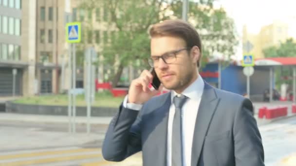Homme d'affaires parlant au téléphone tout en marchant dans la rue — Video