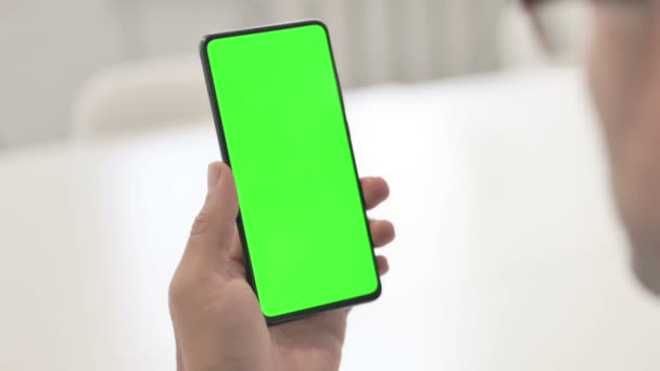 Man op zoek naar Smartphone met Green Chroma Screen — Stockvideo