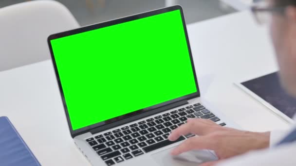 Un barbat care foloseste laptopul cu ecran verde de croma — Videoclip de stoc