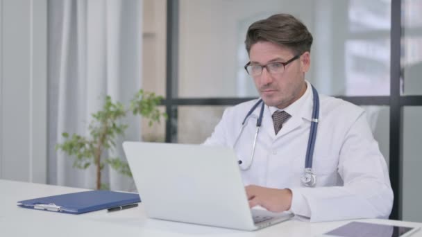 Orvos laptoppal A Klinika kameráját nézi — Stock videók