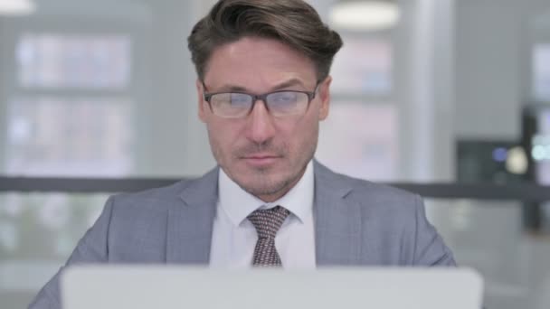 Primer plano del hombre de negocios de mediana edad con el ordenador portátil mostrando pulgares hacia abajo — Vídeos de Stock