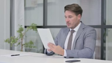 Orta Yaşlı Adam Ofiste Otururken Tabletteki Kayıplara Tepki Veriyor