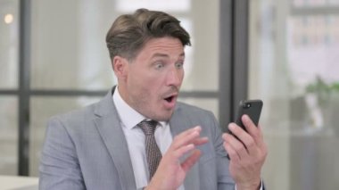 Orta yaşlı adam akıllı telefon kullanırken kayboluyor. 