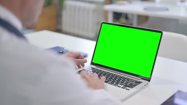 医生使用带有绿色彩色屏幕的笔记本电脑 — 图库视频影像