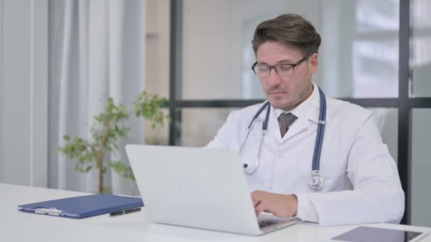 Médico con Laptop mostrando pulgares hacia arriba en la clínica — Vídeo de stock