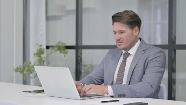 Uomo di mezza età con dolore al polso durante l'utilizzo sul computer portatile — Video Stock