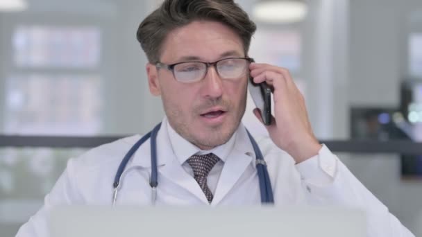 Närbild av läkare med bärbar dator prata på telefon — Stockvideo