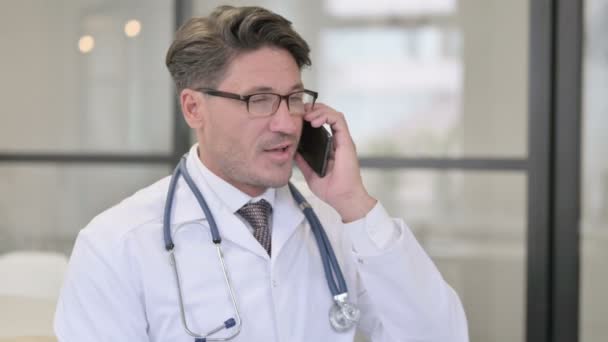 Portret van dokter praten over telefoon — Stockvideo