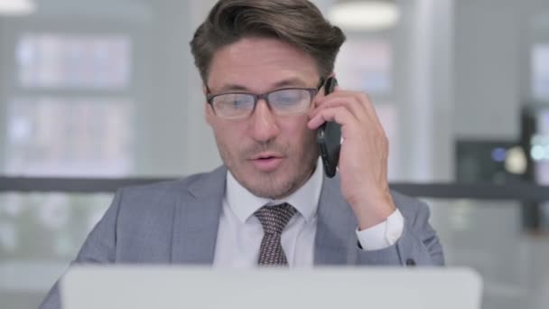 Close Up of Empresário de Idade Média com Laptop Talking no telefone — Vídeo de Stock