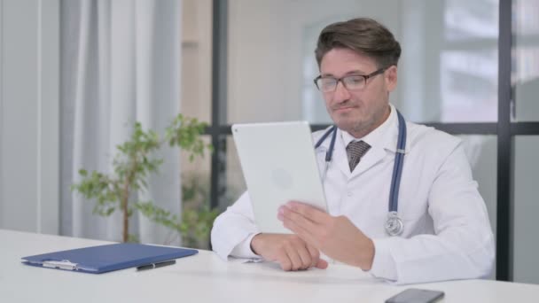 Läkare talar på videosamtal på Tablet i kliniken — Stockvideo