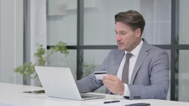 Mann mittleren Alters scheitert mit Online-Zahlung auf Laptop im Büro — Stockvideo