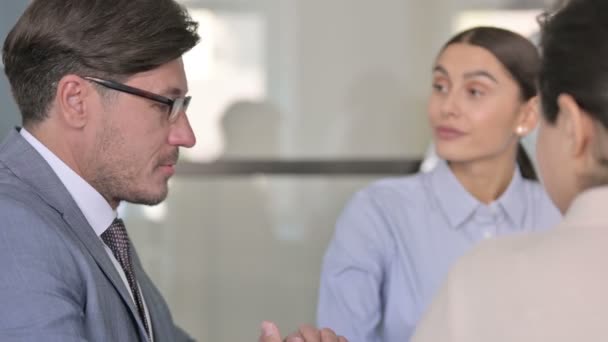 Nahaufnahme von ernsthaften männlichen und weiblichen Geschäftsleuten, die miteinander reden — Stockvideo