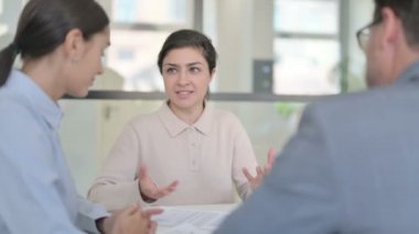 Ofiste otururken iş arkadaşlarıyla konuşan Hintli iş kadını