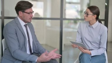 Tabletli Ciddi Genç Kadın Orta Çağ İşadamıyla Konuşuyor