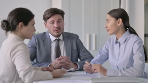 Ελκυστική άνδρες και γυναίκες επιχειρηματίες μιλώντας ενώ κάθεται στο γραφείο — Αρχείο Βίντεο