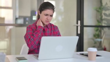 Dizüstü bilgisayarda yazarken boynu ağrıyan Hintli kadın 