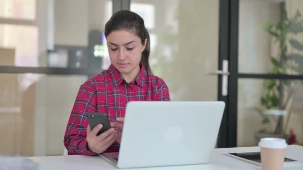 Indiai nő használ okostelefon, miközben dolgozik a Laptop — Stock videók
