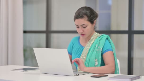 Індійська жінка з запальним болем використовує лаптоп в офісі — стокове відео