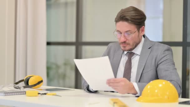 Ingeniero de mediana edad celebrando el éxito mientras lee documentos en el cargo — Vídeo de stock