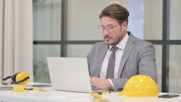 Ingeniero de mediana edad celebrando el éxito mientras usa el ordenador portátil en la oficina — Vídeo de stock