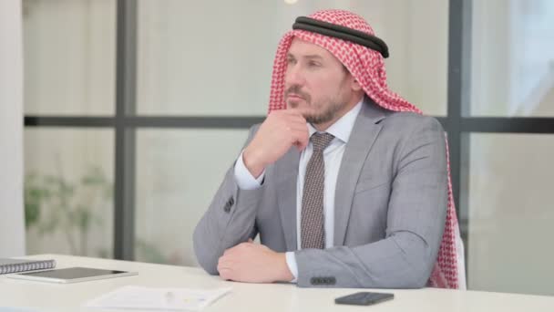 Заботливый арабский бизнесмен среднего возраста думает во время работы в офисе — стоковое видео