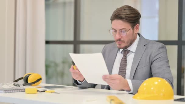 Middeleeuws ingenieur die rapporten leest terwijl hij op kantoor zit — Stockvideo