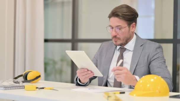 Sestava zápisu inženýra středního věku při použití tabletu v kanceláři — Stock video