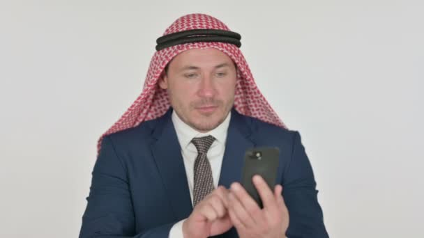 Arab Businessman świętuje na smartfonie, białe tło — Wideo stockowe