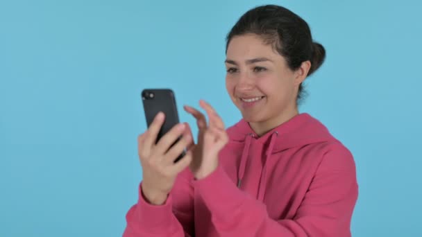 Indiska flicka med hjälp av smartphone, blå bakgrund — Stockvideo
