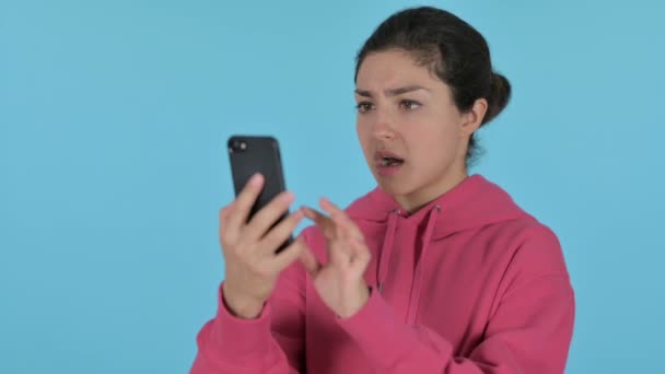 Indian Girl Reacting to Loss on Smartphone, Blue Background — Stock Video